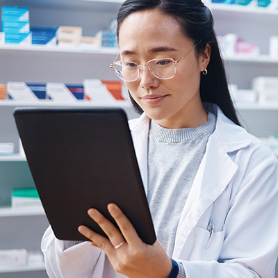 pharmacist with tablet in pharmacy