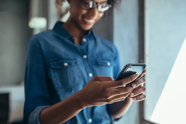 Woman using cell phone to view iCare+ test kit results