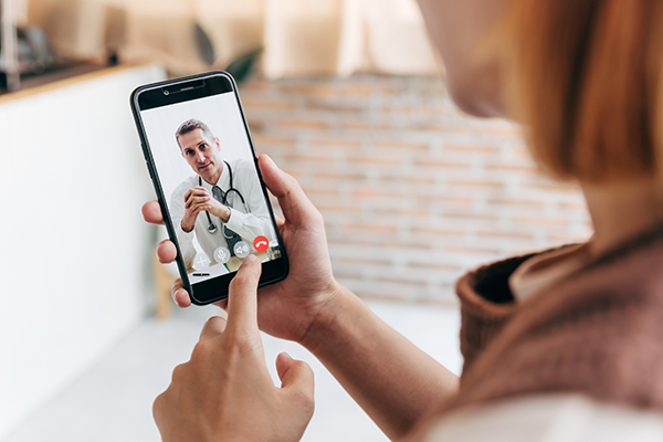 Young woman meet her doctor via video call by smart phone at hom